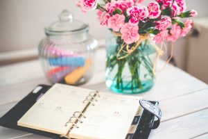 home stager planning calendar on desk with flowers