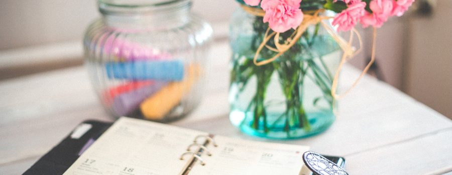 home stager planning calendar on desk with flowers