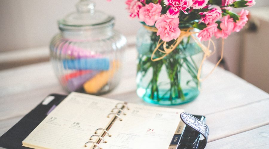 home stager planning calendar on desk with flowers